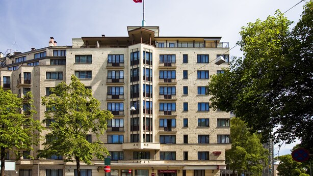 A multi-story hotel with a flat facade, balconies, and a flag on top. - Thon Hotel Slottsparken (Oslo)