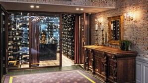 Un intérieur luxueux agrémenté d’un magnifique lustre, d’une cave à vin et d’un tapis à motifs.