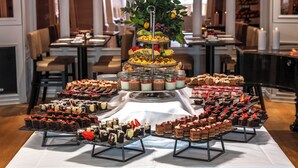 A buffet table with various desserts and a tiered fruit arrangement. - Thon Hotel Slottsparken (Oslo)