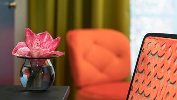 Un florero de vidrio transparente con una flor rosa sobre una mesa.