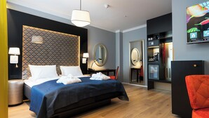 A modern hotel room with a large bed, a desk, a mirror, and a television displaying hotel information. - Thon Hotel Spectrum (Oslo)
