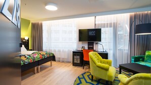 A hotel room with a bed, a desk with a computer, a television, and a chair. - Thon Hotel Vika Atrium (Oslo)
