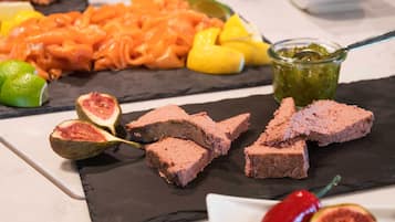 Une planche de charcuterie garnie de viandes en tranches, de figues et d’un pot de chutney.