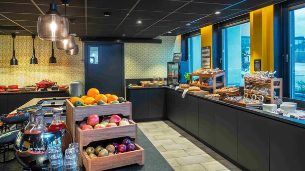 Un bufé de desayuno con diversas frutas, pasteles y bebidas.