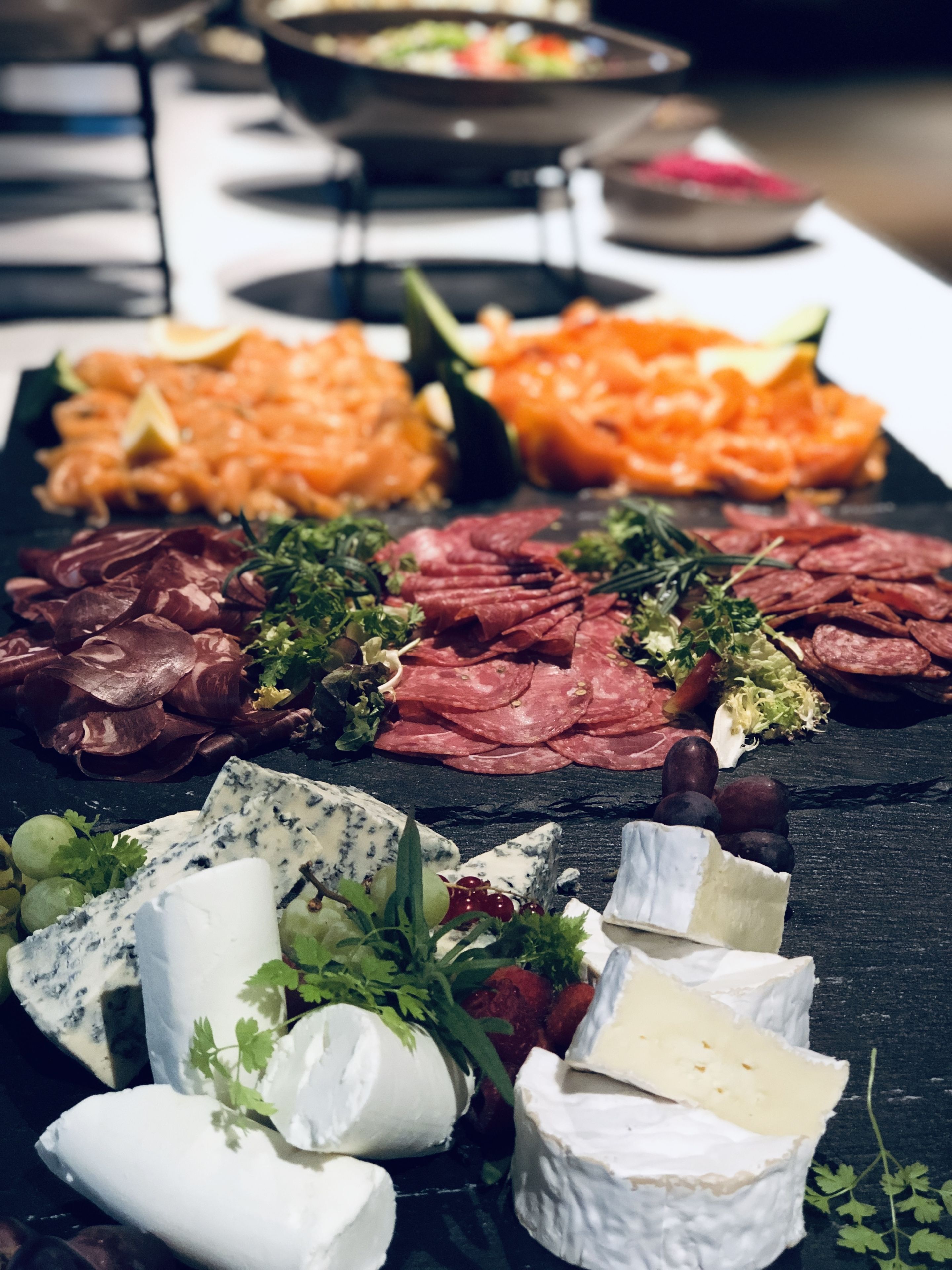 Une planche de charcuterie avec divers fromages, viandes et accompagnements.