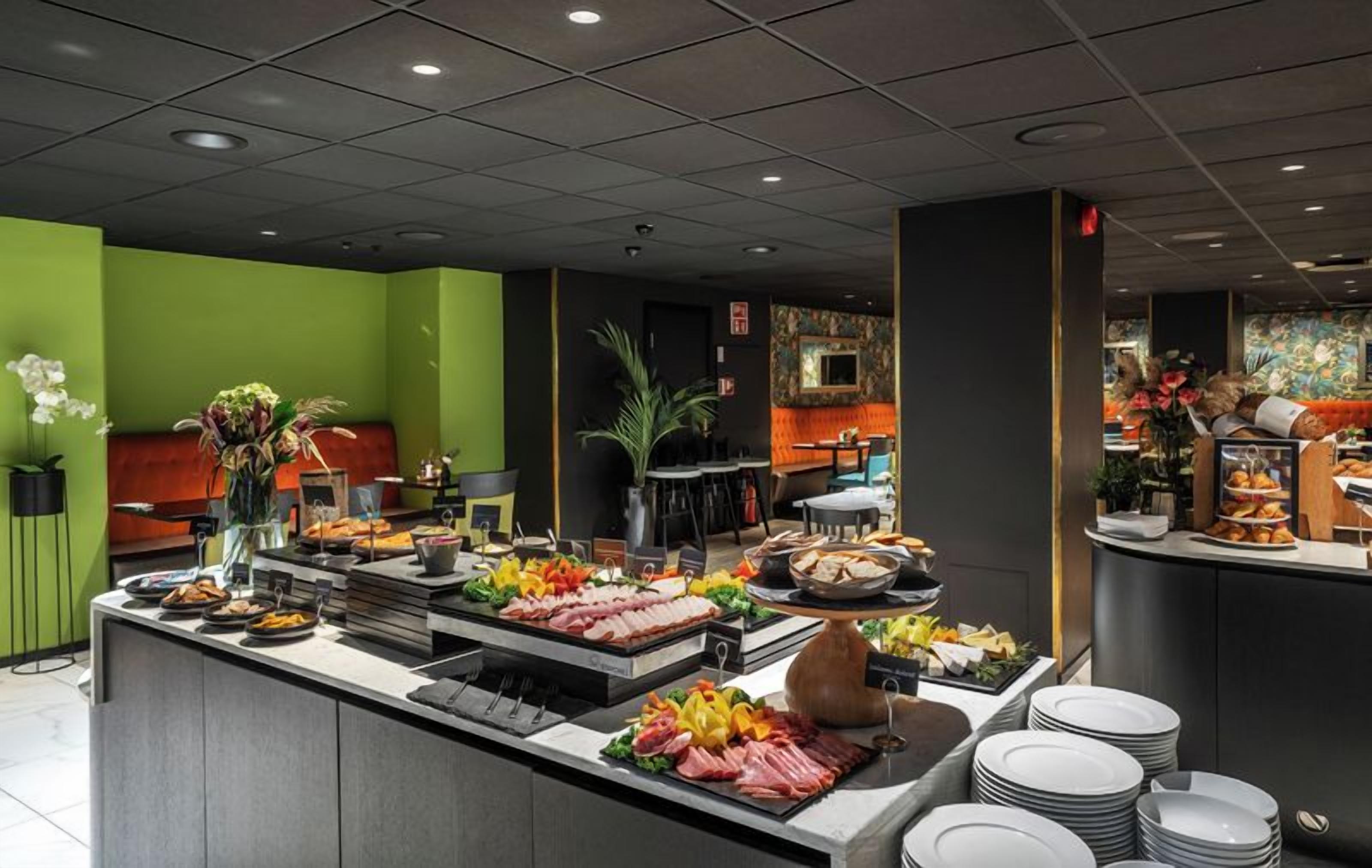 A buffet area with various food options, a seating area, and a counter with a cash register.