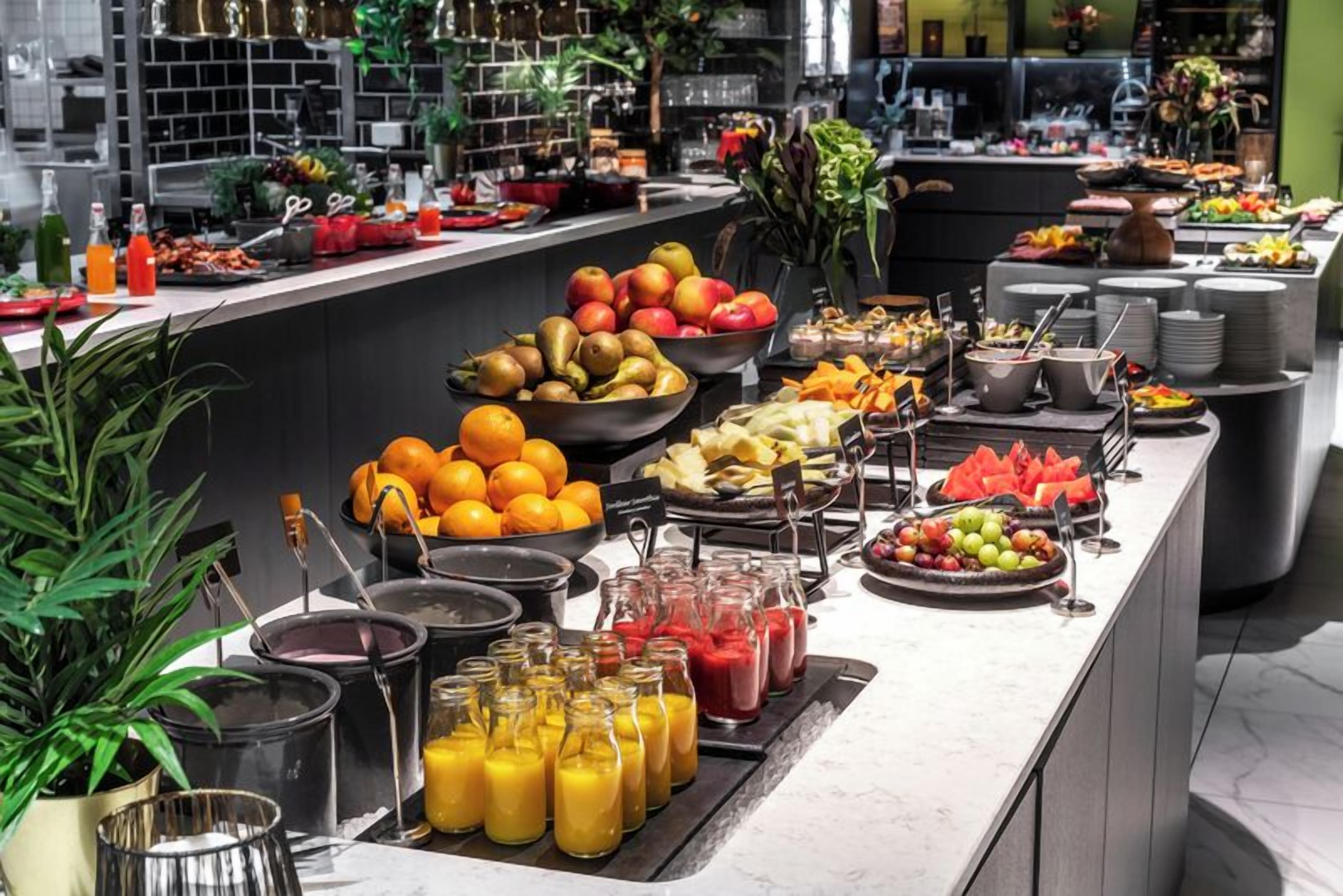 Un bufé con frutas, verduras y bebidas variadas.