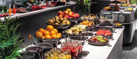 Un bufé con frutas, verduras y bebidas variadas.