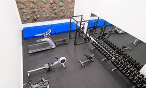 A gym with various exercise equipment including treadmills, weight machines, and a rock climbing wall. - Thon Hotel Bergen Airport (Bergen)