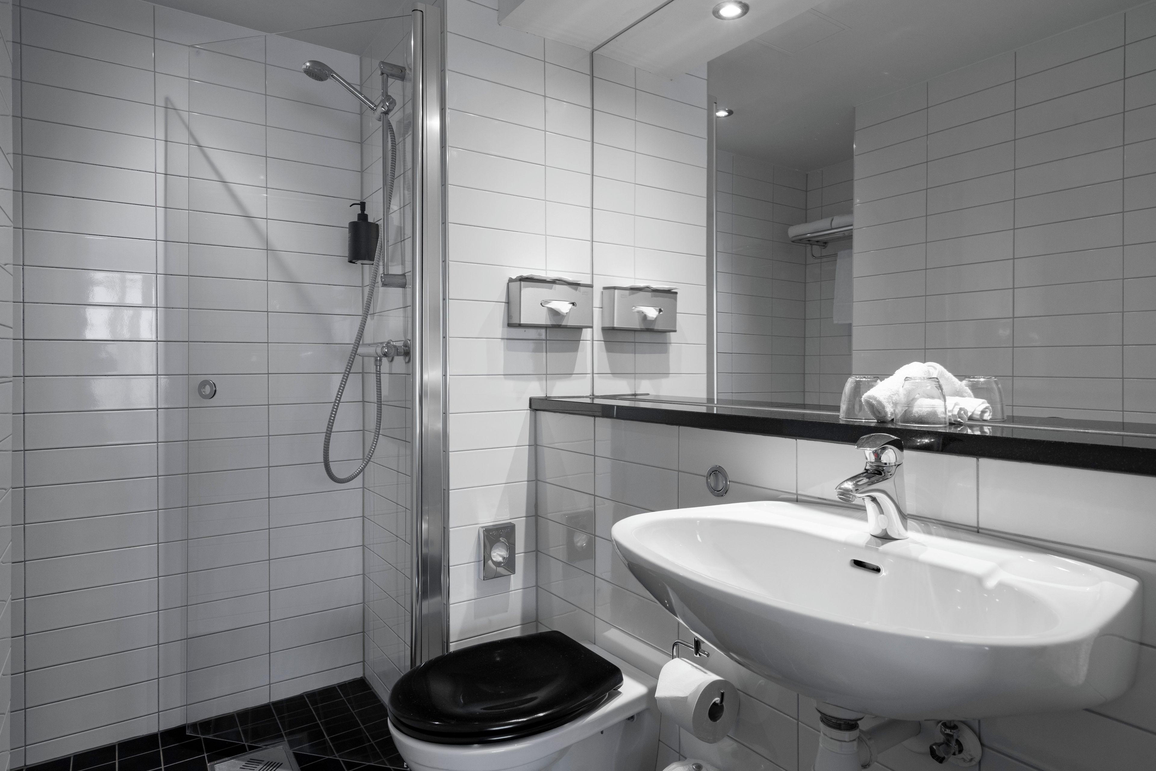 A modern bathroom with a shower, toilet, and sink.