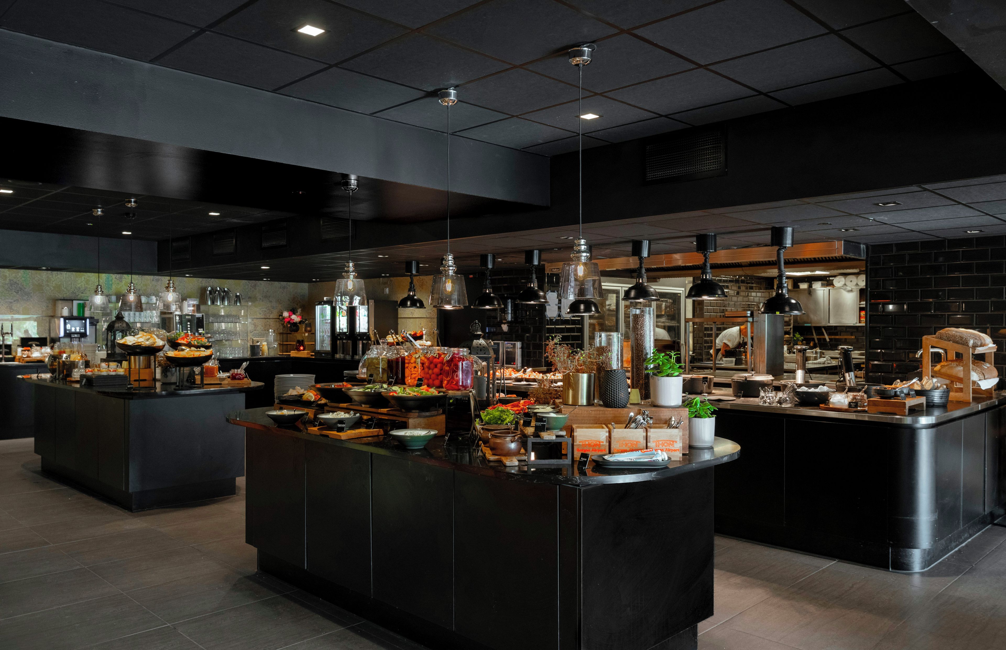 A modern kitchen with multiple islands, equipped with various appliances and utensils.