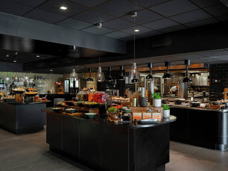 A modern kitchen with multiple islands, equipped with various appliances and utensils.