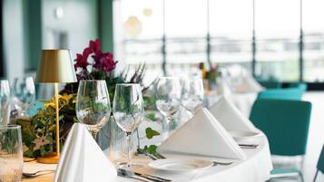 A table set for dining with multiple wine glasses, a lamp, and a vase with flowers.