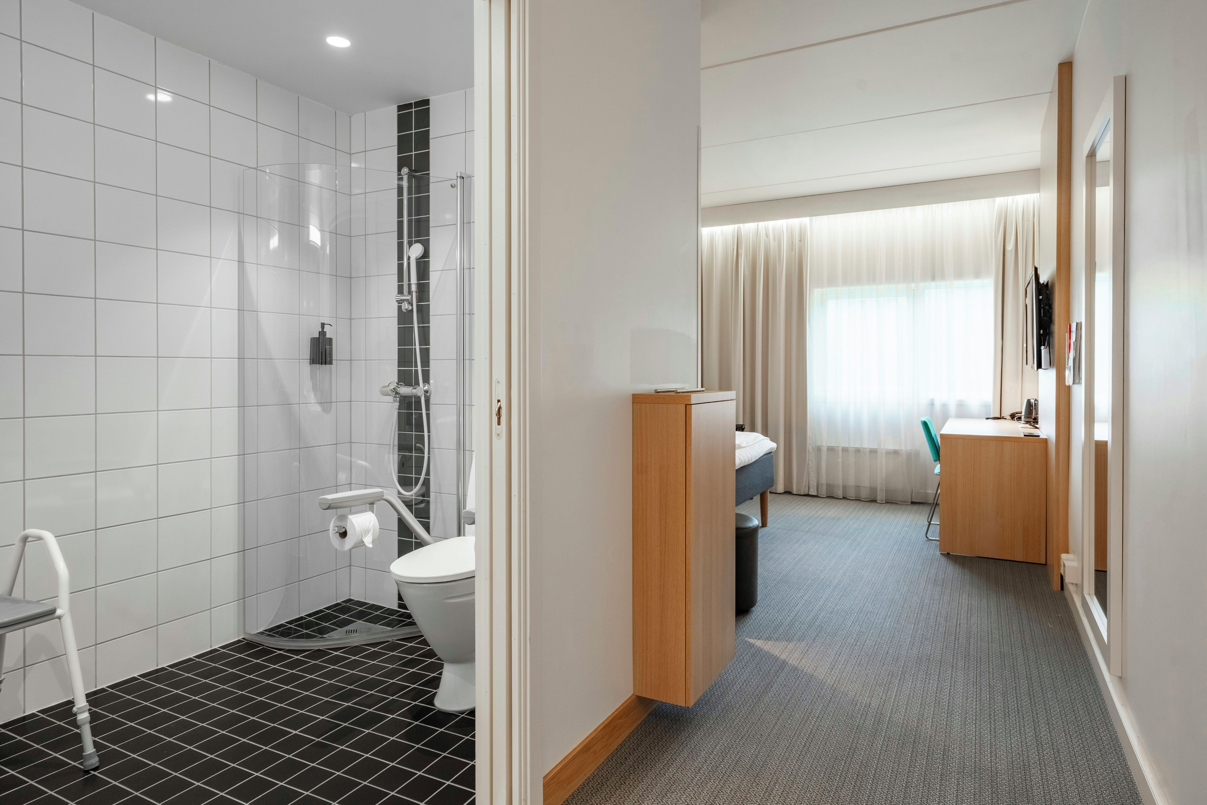 A hotel bathroom with a shower, toilet, and sink.