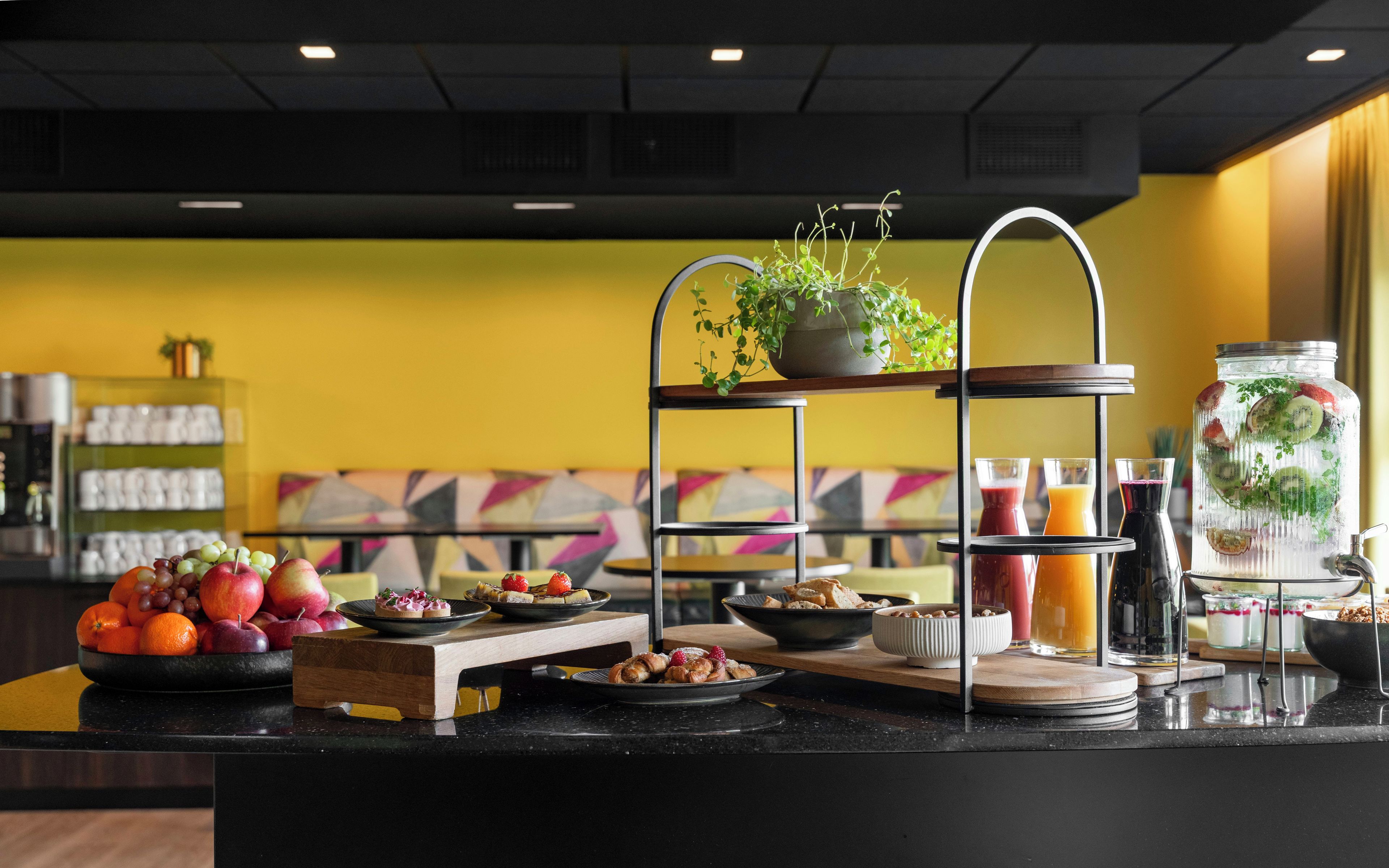 Un bufé de desayuno con diversas frutas, pasteles y bebidas.