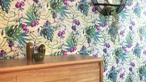 A wooden cabinet with decorative vases against a floral wallpaper backdrop. - Thon Hotel Storgata (Kristiansund)