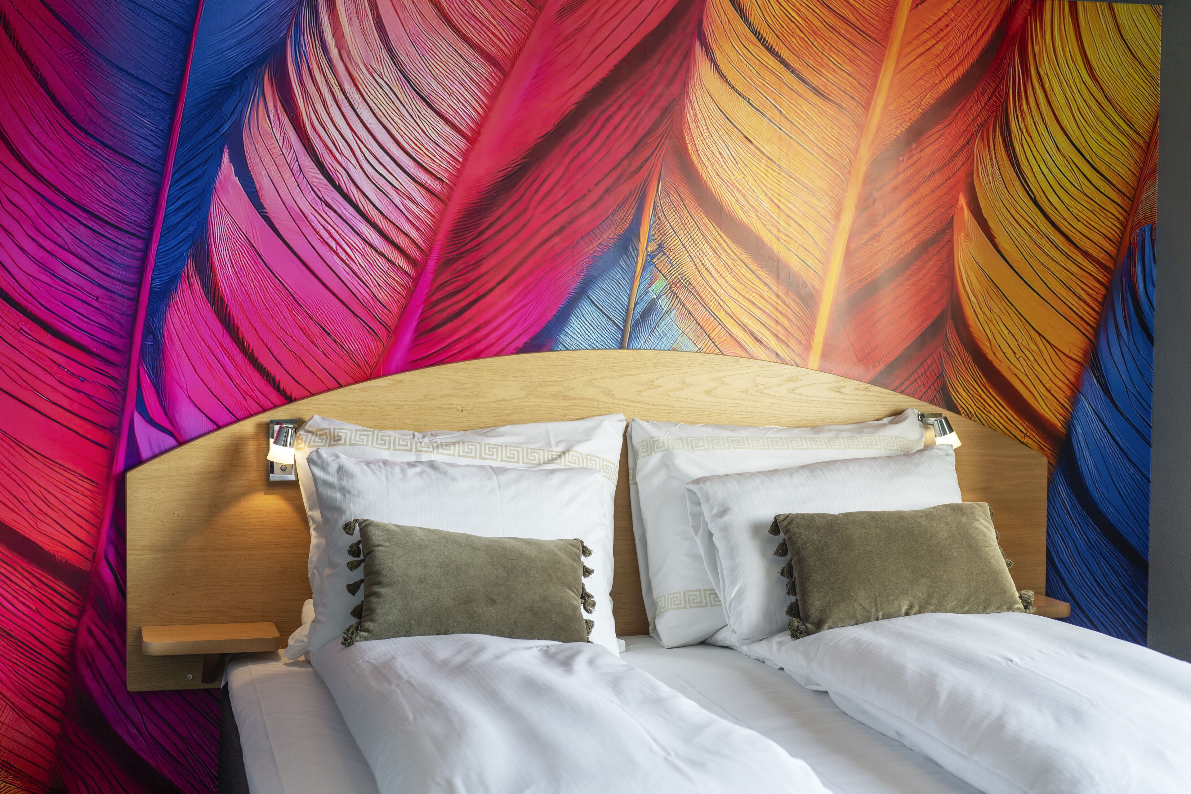 A bed with white linens, two pillows, and a wooden headboard.