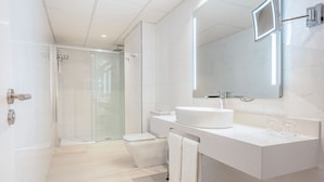 A modern bathroom with a glass-enclosed shower, a white sink, and a large mirror. - Hotel Best Auto Hogar (Barcelona)