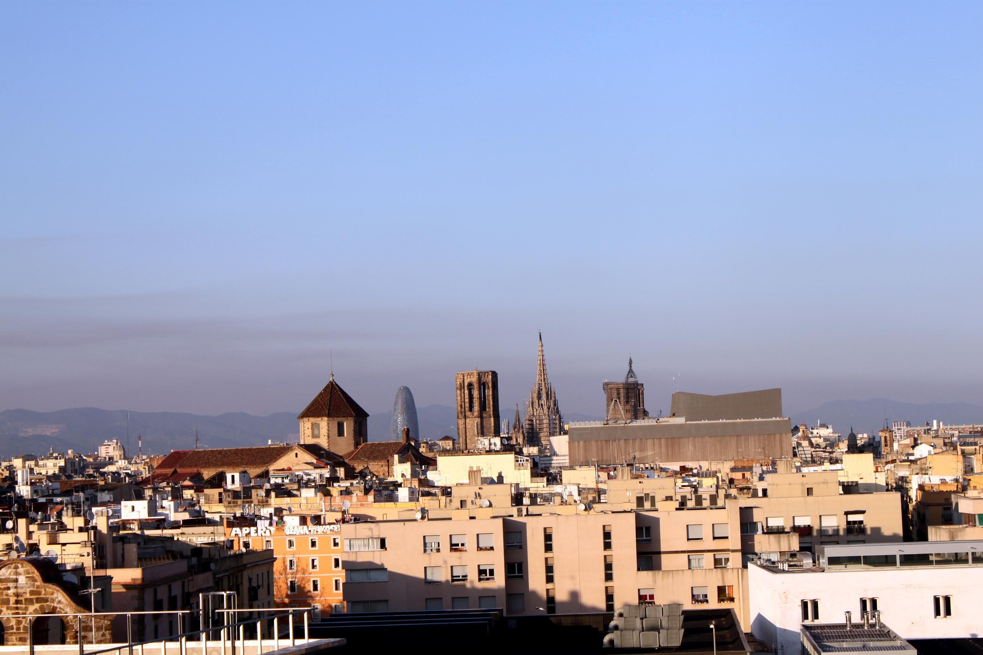 En stadsbild med historiska byggnader och modern arkitektur, inklusive en framträdande katedral och en stor, modern byggnad.