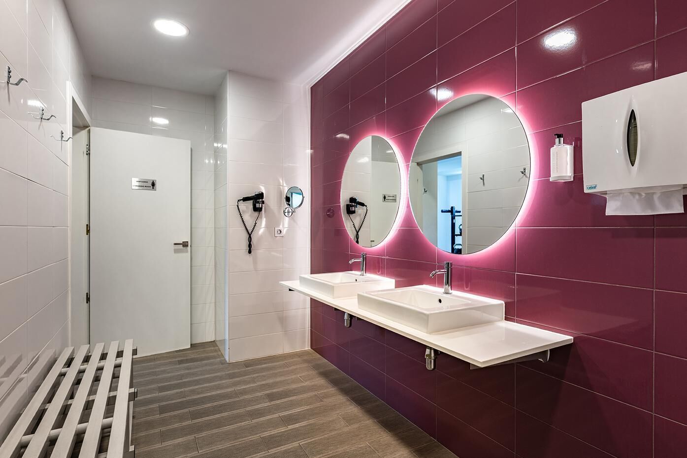 Un baño moderno con dos lavamanos, un espejo y zona de ducha.