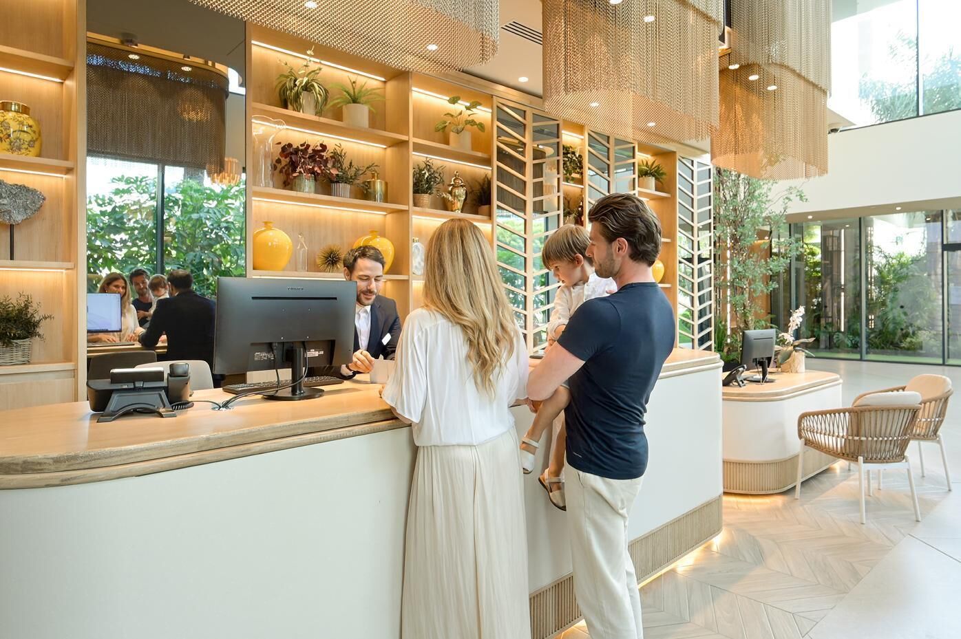 A modern reception area with a counter, computer, and seating area.
