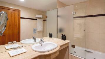 Un baño moderno con dos lavamanos, un espejo grande y una ducha con paredes de vidrio.