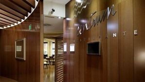 A modern interior with a curved wooden wall and a sign reading "Centrum Restaurante".