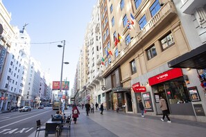 A city street with a hotel named 'VIPS' on the right, featuring a red awning and a signboard.