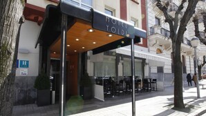 A hotel entrance with a covered outdoor seating area and a sign reading "HOTEL YOLDI". - Hotel Yoldi (Pamplona)