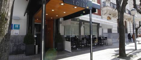 Entrada de un hotel con un área de estar al aire libre techada y un letrero que dice "HOTEL YOLDI".