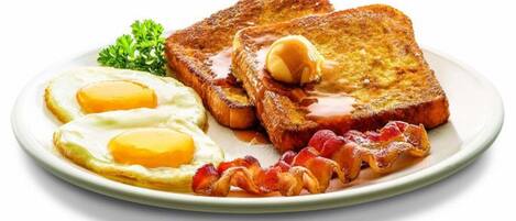 A plate with two fried eggs, two slices of toast with butter, and bacon.