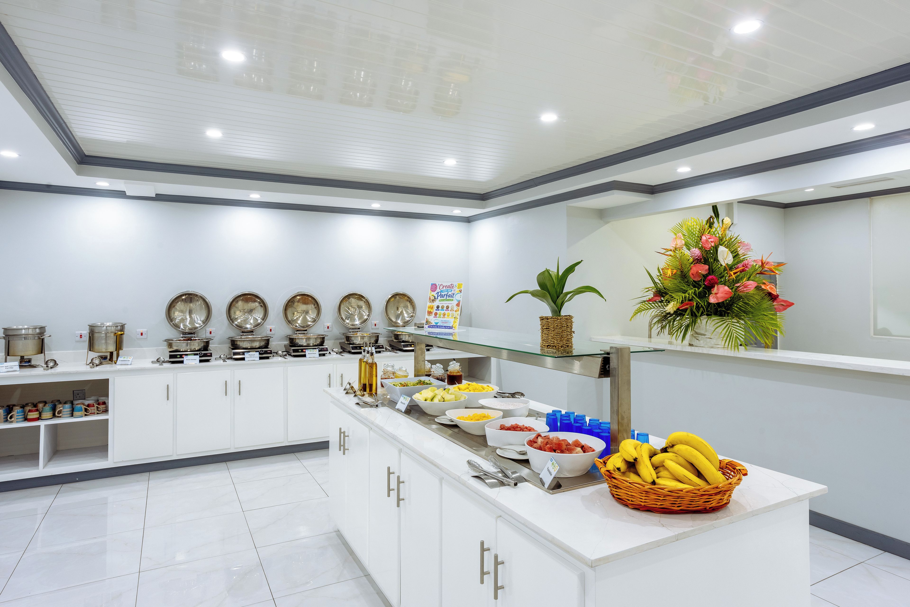 A buffet setup with various food items and a decorative plant.