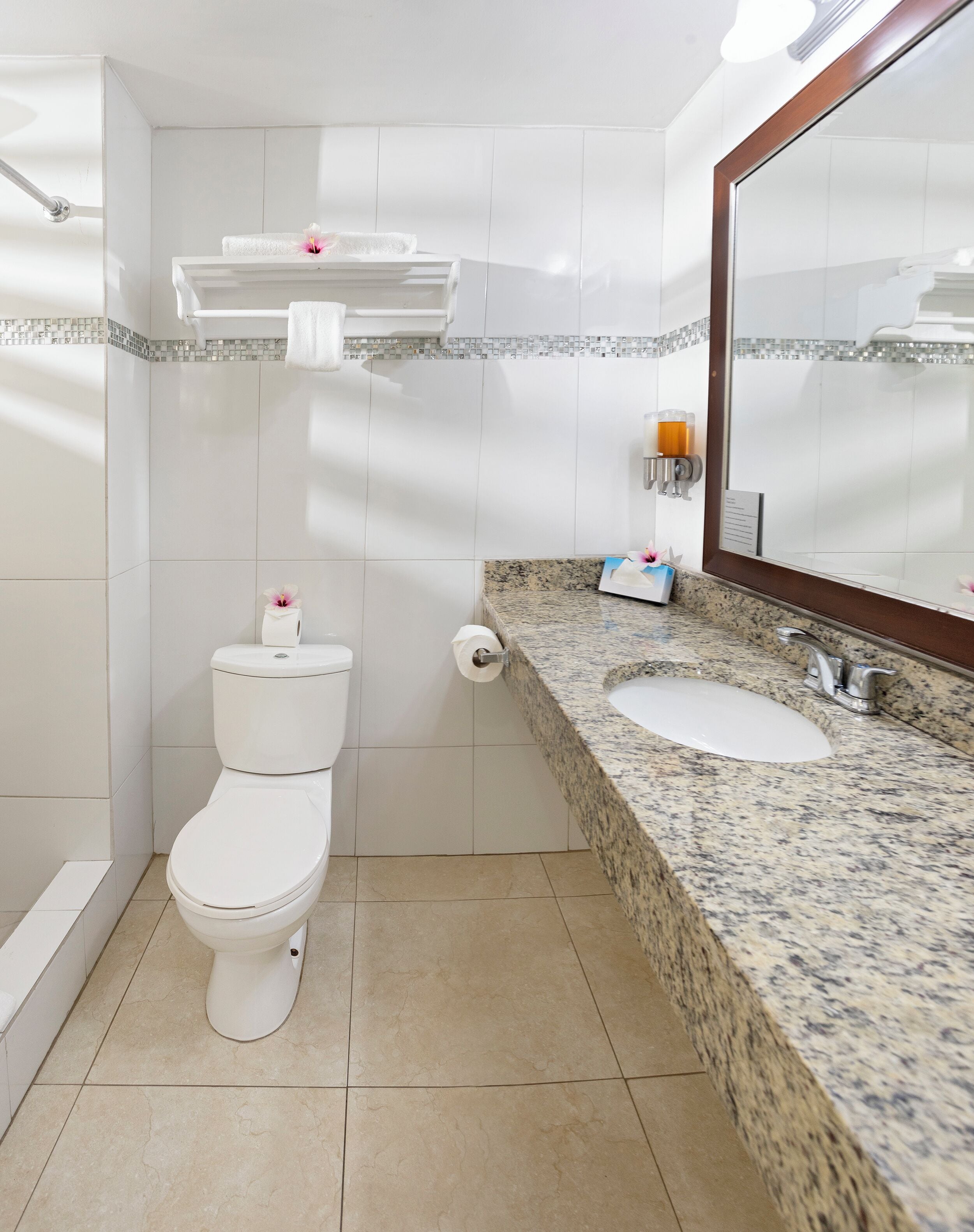A bathroom with a toilet, sink, and mirror.