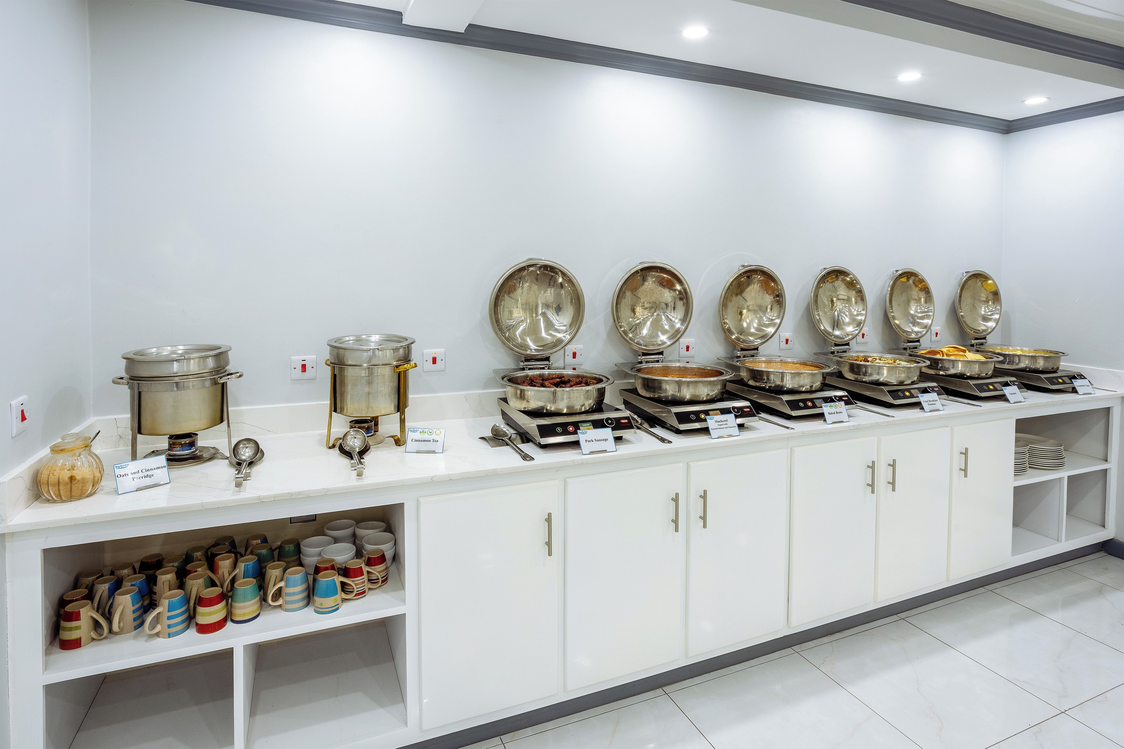 A buffet setup with various food stations and utensils.