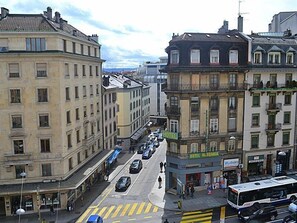 A street view with a hotel named 'HOTEL AKODANIA' on the corner, featuring a traditional European architectural style with multiple stories and a classic facade. - Hotel Moderne Genève (Geneva)