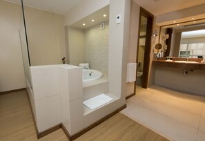 A modern bathroom with a large mirror, a sink, and a shower area.