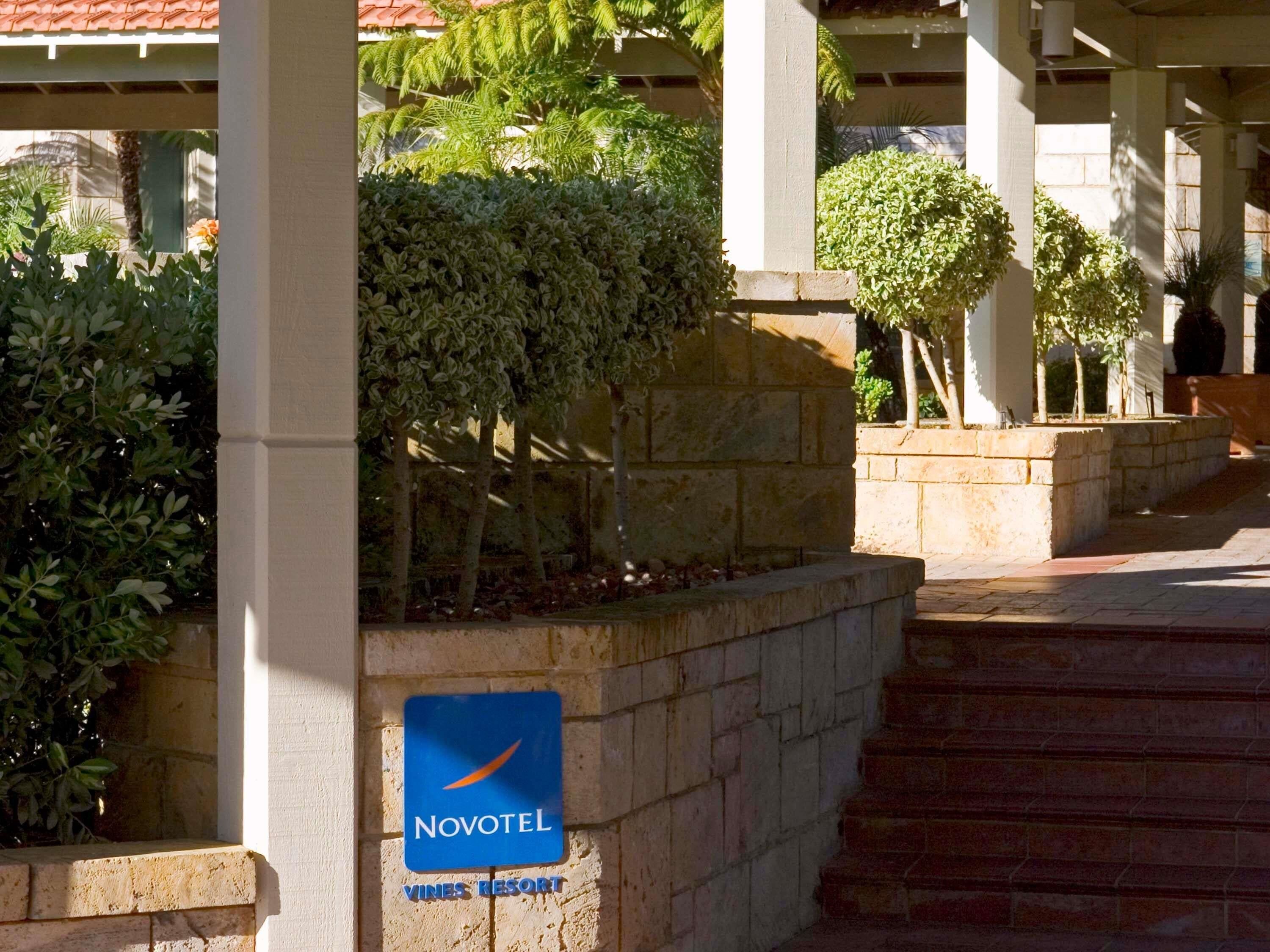 A hotel entrance with a sign for Novotel Vines Resort.