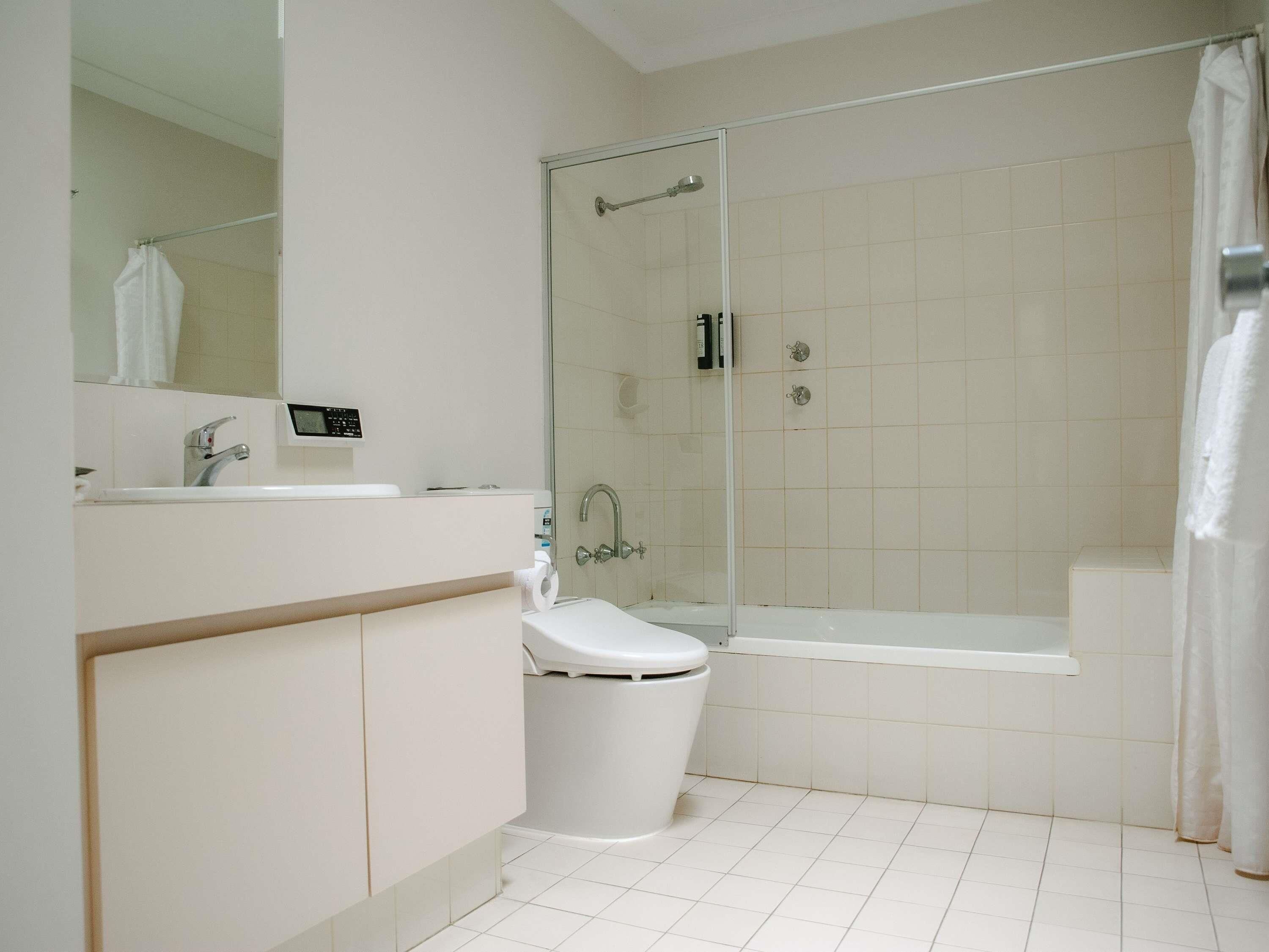 A modern bathroom with a toilet, sink, and shower area.