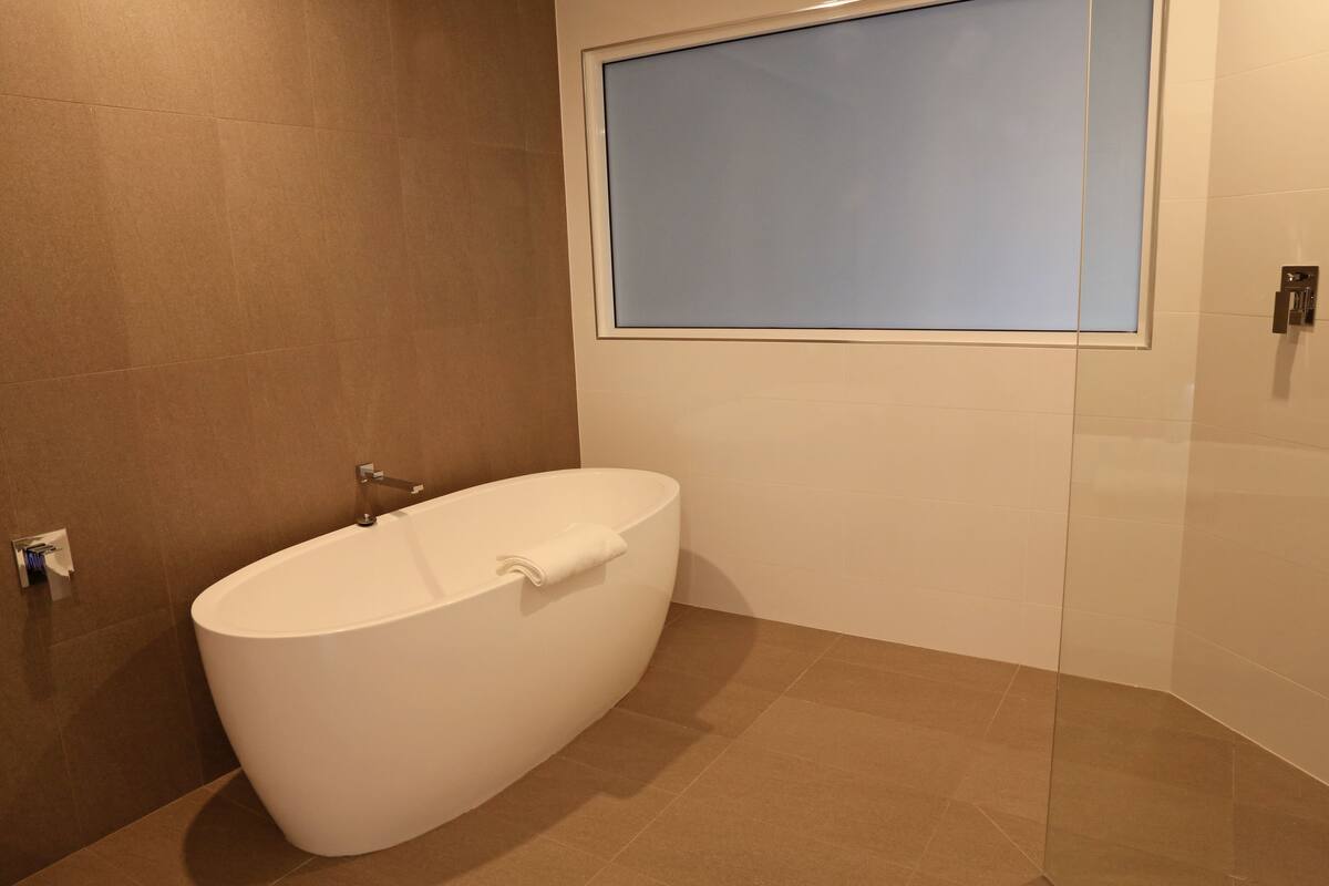 deluxe room, 1 king bed | bathroom | shower, eco-friendly toiletries, hair dryer, towels