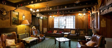 Una sala de estar acogedora con muebles de cuero, una alfombra estampada y una chimenea.