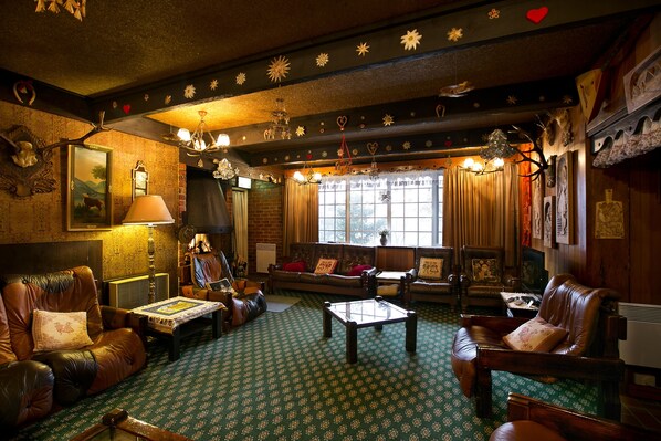 Una sala de estar acogedora con muebles de cuero, una alfombra estampada y una chimenea.