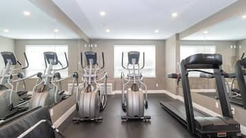 Ein Fitnessstudio mit Laufbändern, Crosstrainern und stationären Fahrrädern.