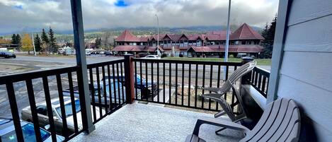 A balcony with a view of a parking lot and buildings.