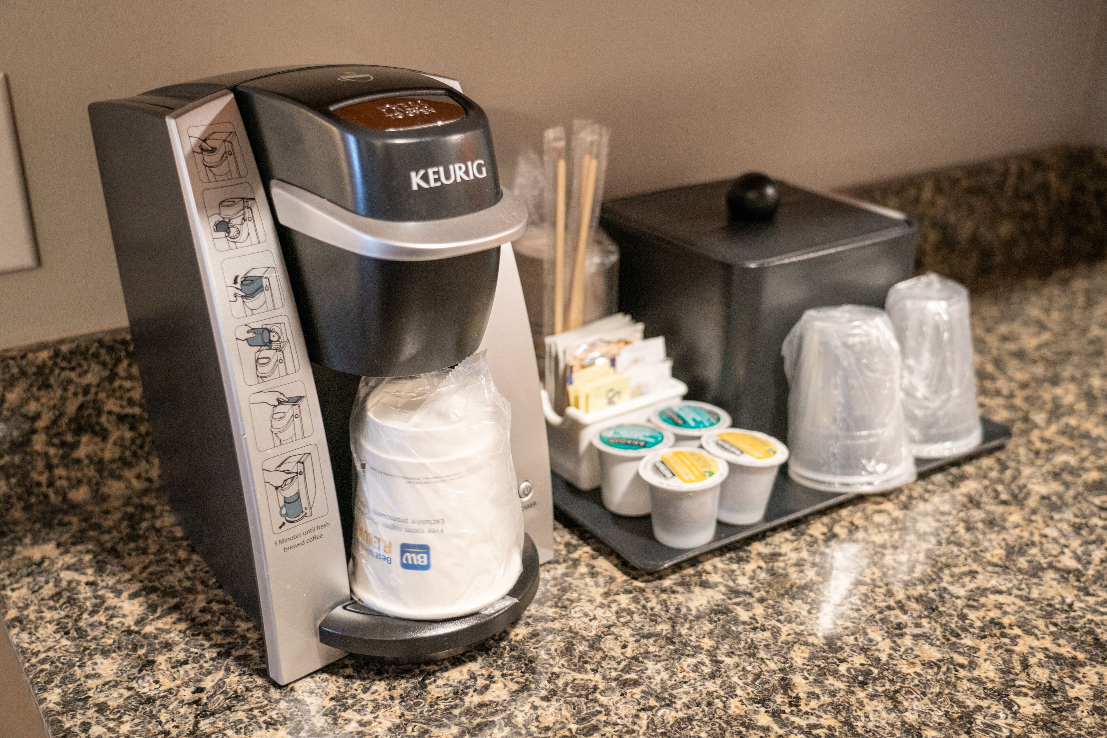 A Keurig coffee machine with a drip tray, coffee pods, and a water reservoir.
