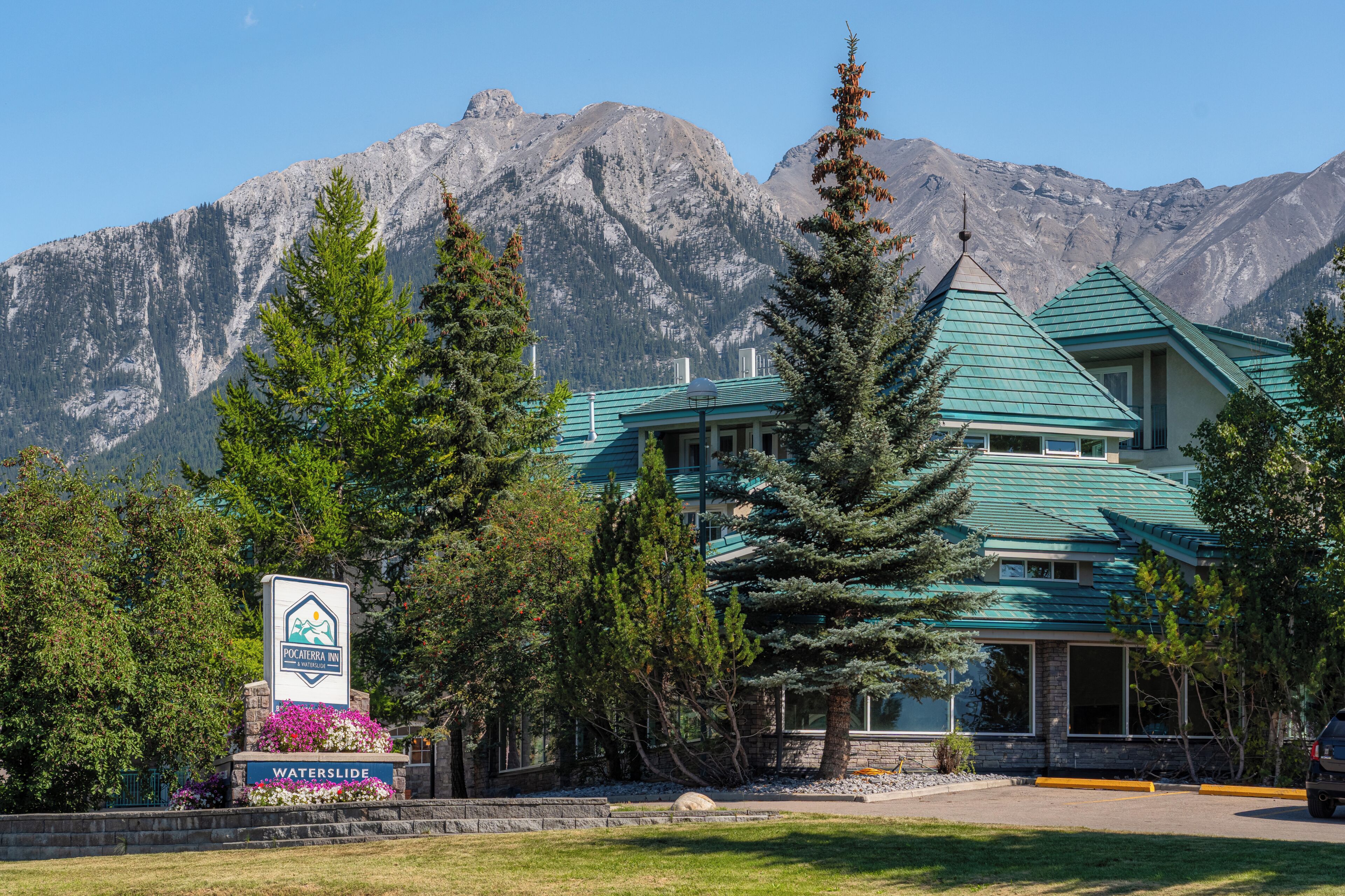 A hotel with a mountain backdrop, a sign indicating 'Pocaterra Inn & Waterslide,' and a 'Waterslide' sign.