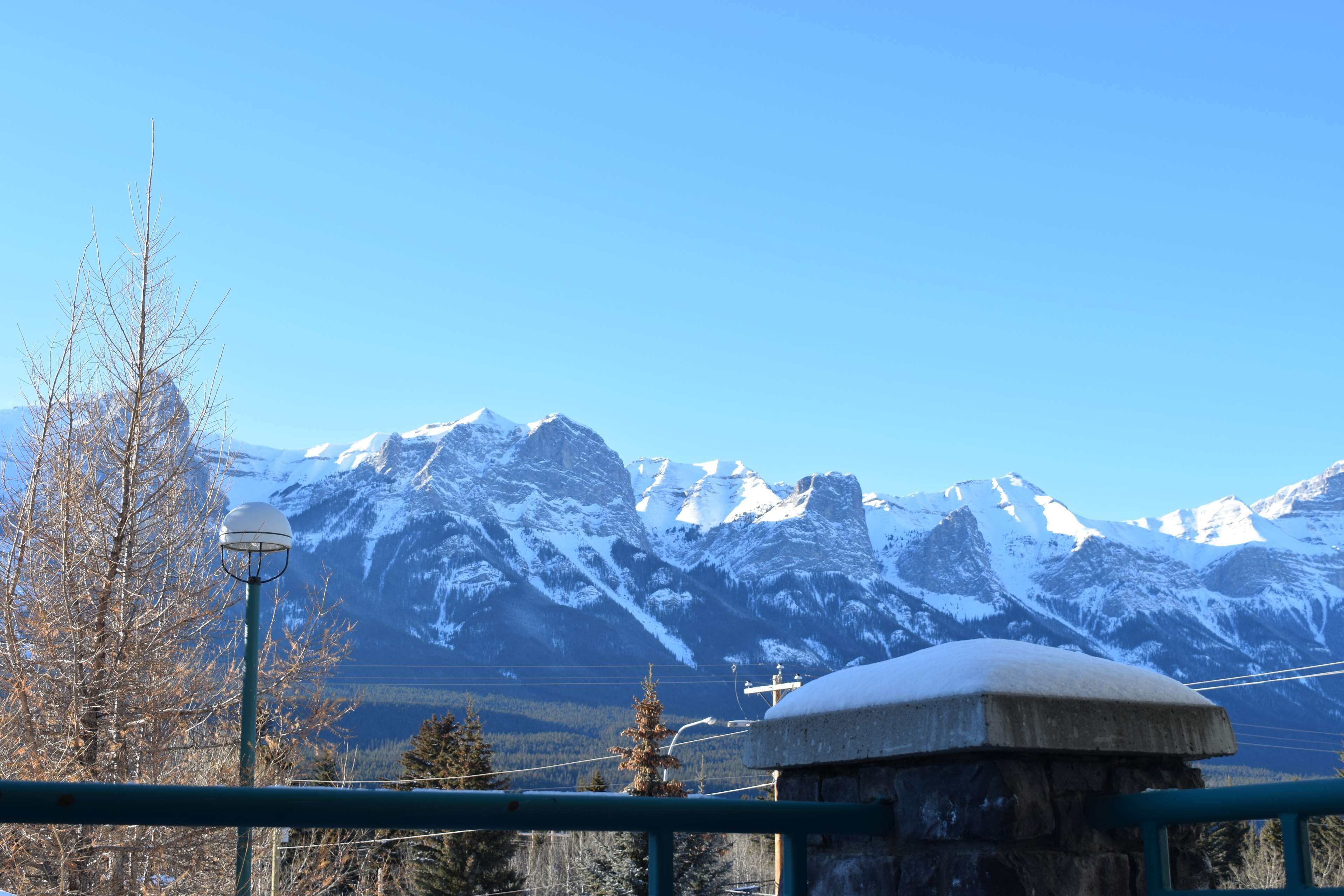 Paisaje montañoso con picos nevados y cielo despejado.