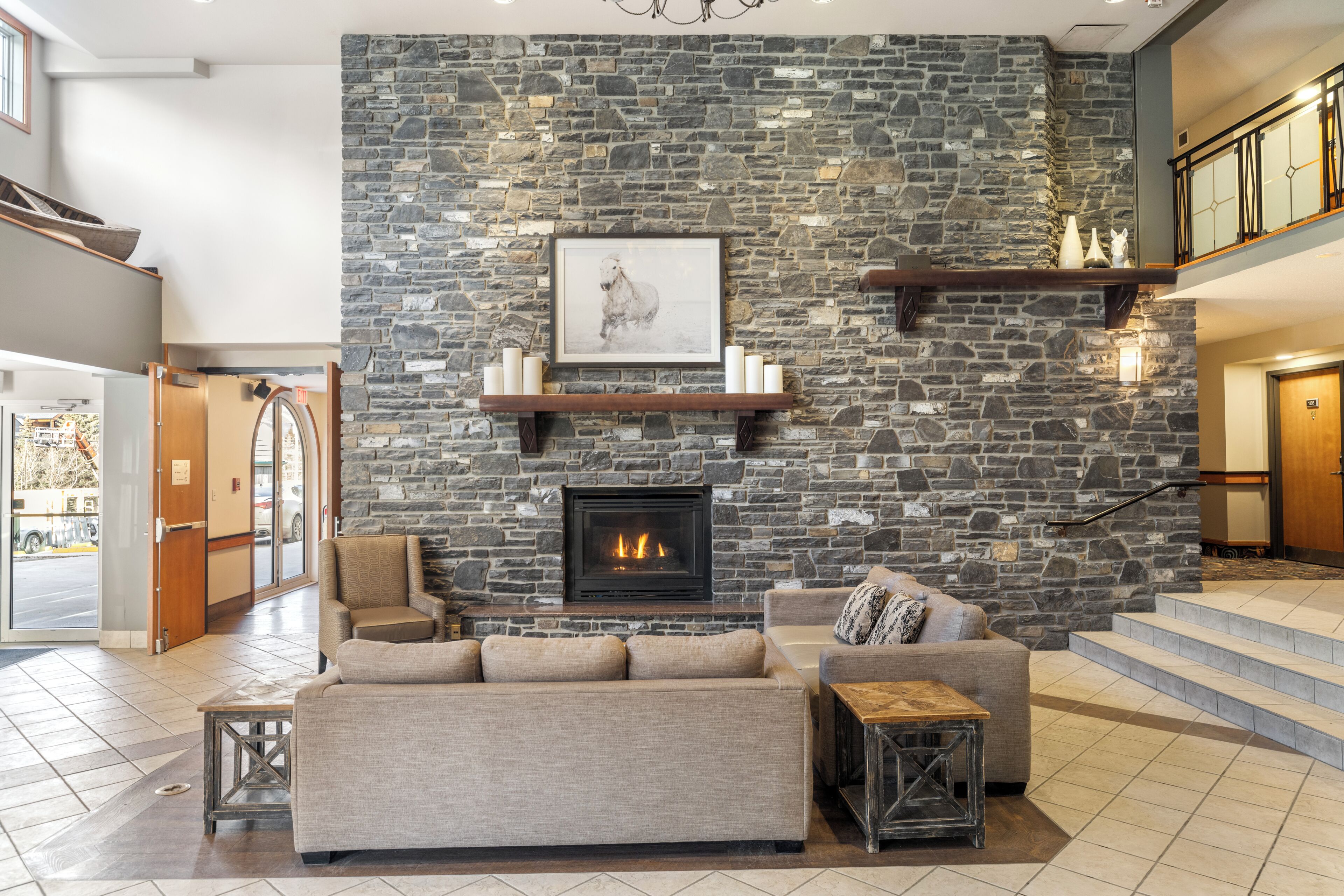A modern living room with a stone wall, fireplace, and a sofa.