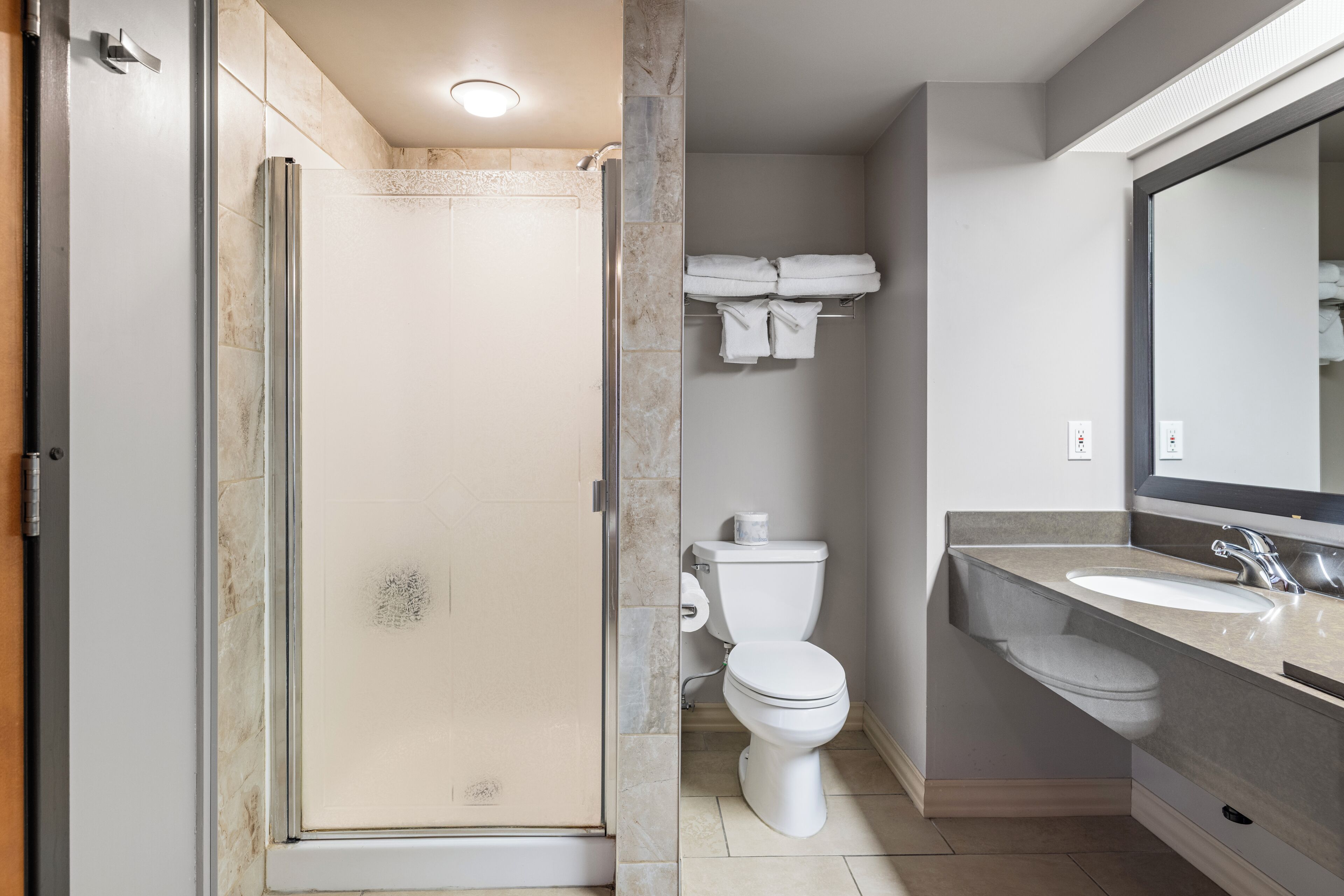 A bathroom with a shower, toilet, and sink.