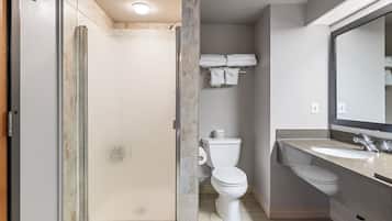 A bathroom with a shower, toilet, and sink.