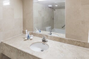 Bathroom features a clean, minimalist design with a large mirror and a shower area.